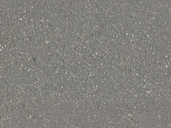 Road texture of asphalt in dark grey tone with small stones embedded consistently in surface.